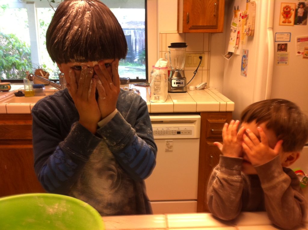 Kids covering their faces with their hands. 