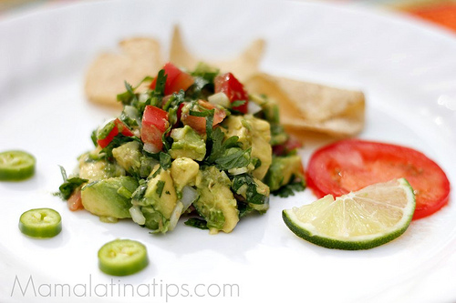A delicious serving of guacamole on a crisp white plate.