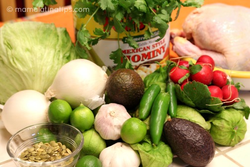 Una lata de maíz pozolero, y otros ingredientes para hacer pozole verde de pollo como cebolla, tomates, chiles.