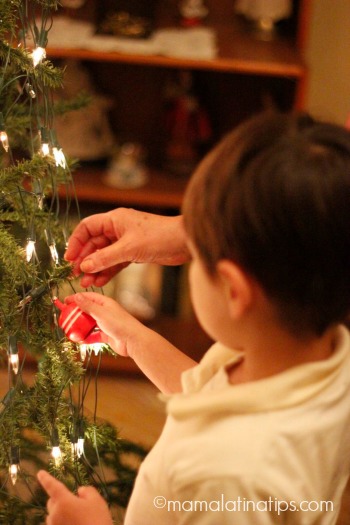 Niño-putting-up-Christmas-ornament