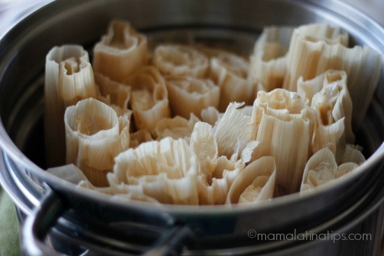 Mexican tamales in a metal pot on a table.