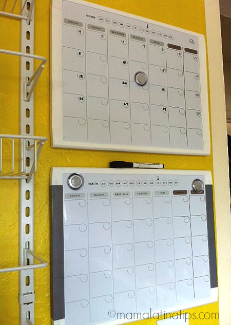 two magnetic, dry erase calendar on a yellow wall