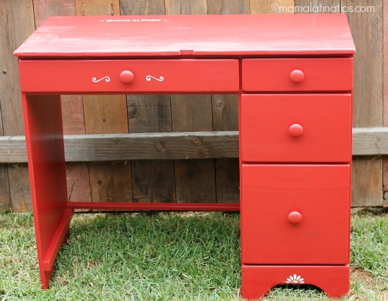 Un escritorio rojo pequeño con cuatro cajones