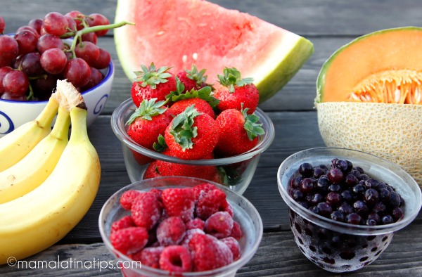 Fruit on glass bowls on a wood table