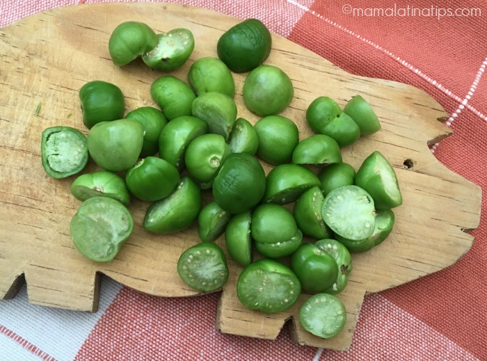 Tomatillos in halves on top of a pig shaped cutting board