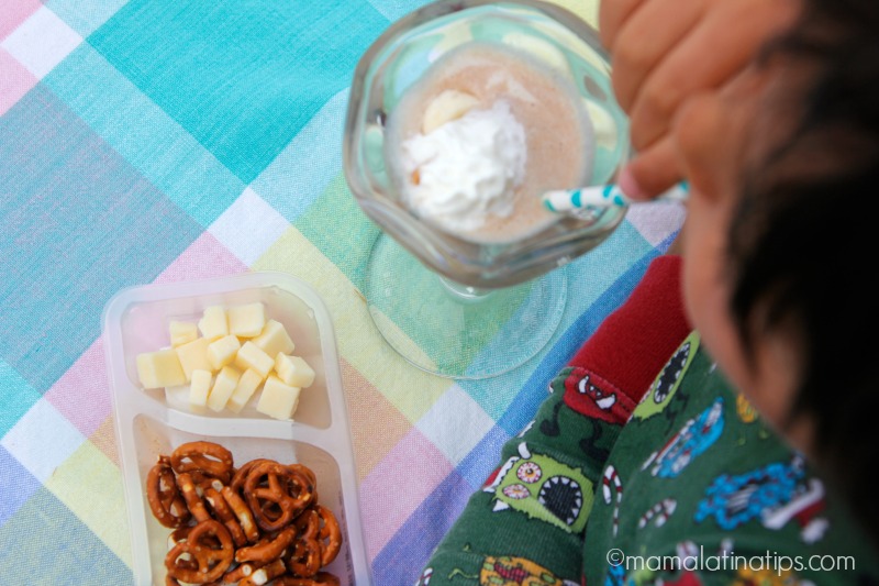 kid eating chocolate milk and a nutritious snack with cheese and pretzels - mamalatinatips.com