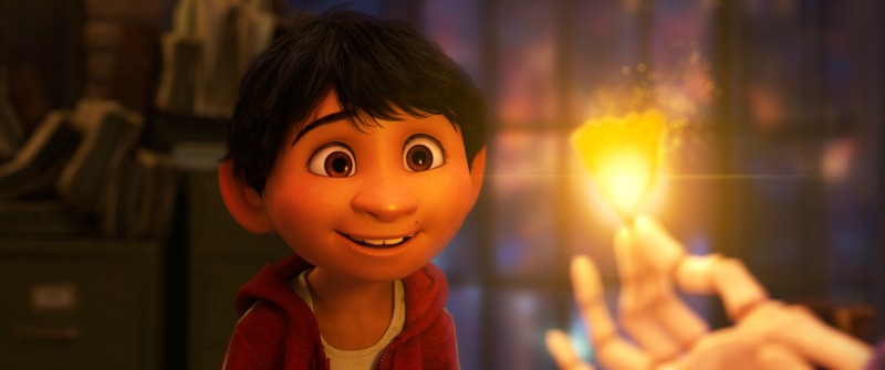Escena de la película de Coco con Miguel viendo un pétalo de cempazuchitl iluminado