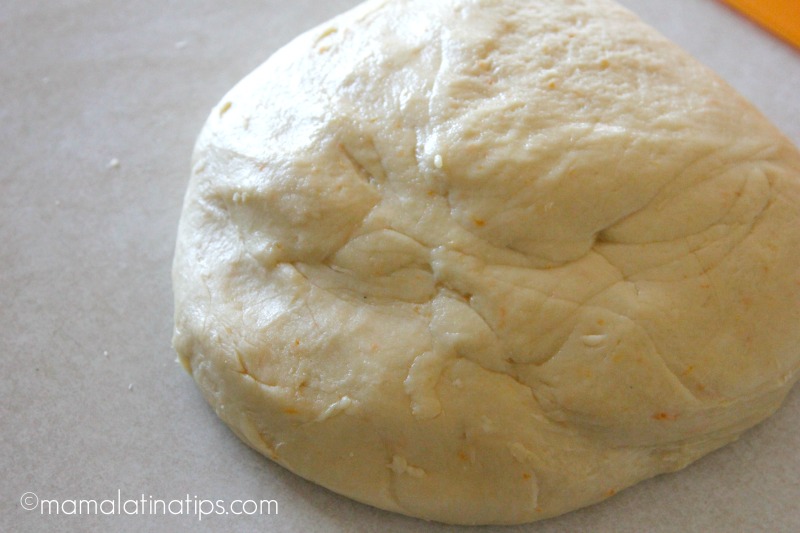 Una bola de masa para hacer rosca de reyes sobre una superficie gris.