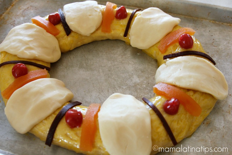 Rosca de reyes antes de hornear adornada con costrones de azúcar y fruta seca. 