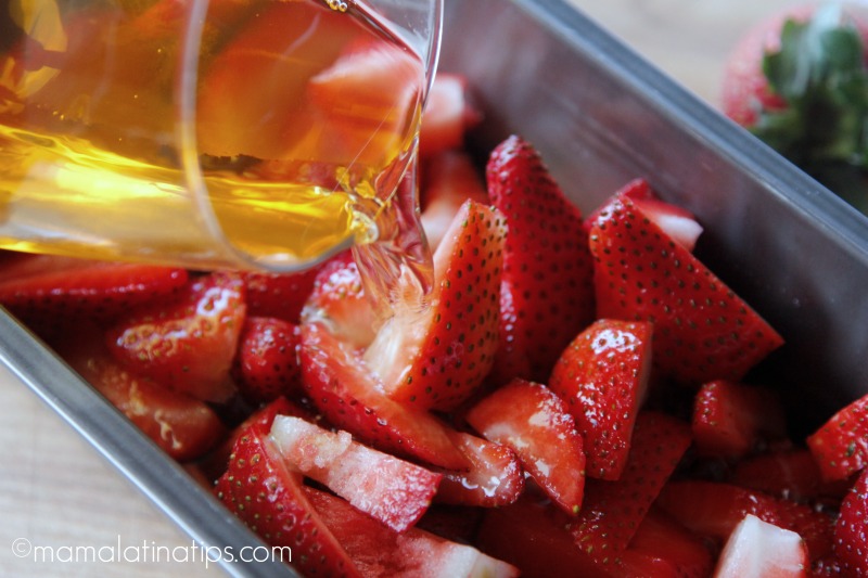 Pouring apple juice on top of fresh strawberries