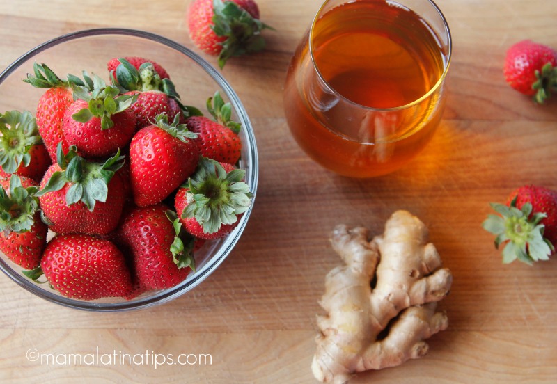 bowl with strawberries, apple juice and ginger root.