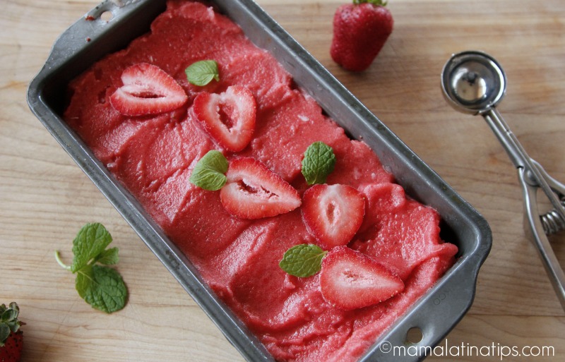 strawberry sorbet in a tray with fresh strawberries on top