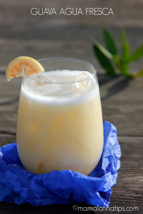 guava agua fresca in a glass on top of a wooden table