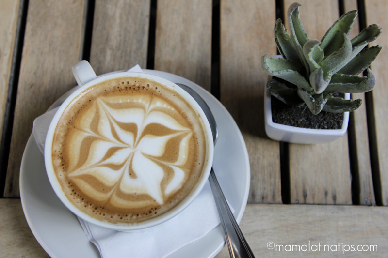 Taza de café con leche con un diseño floral en la espuma