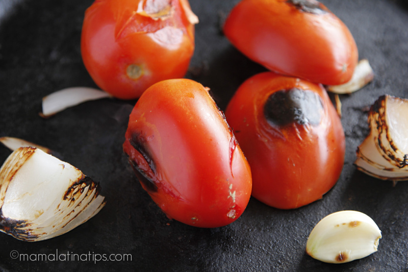 grilled tomatoes, onions, and garlic on a griddle