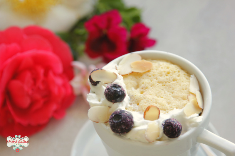 Pastel de Amaretto en Taza decorado con crema batida, frutas del bosque y flores