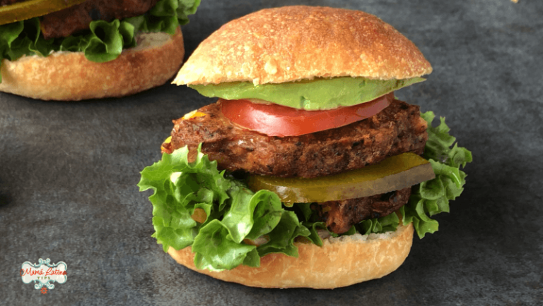 chipotle black bean torta with lettuce, tomato and avocado on a dark background
