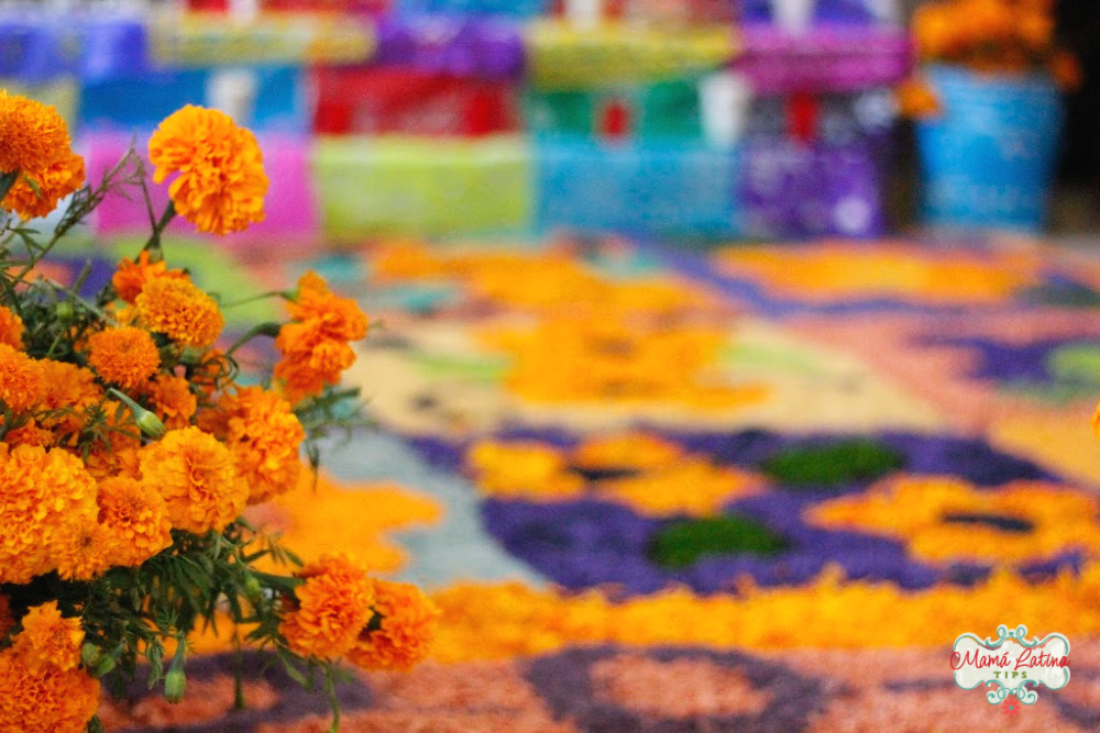 A Day of the Day altar with colorful papel picado and marigolds