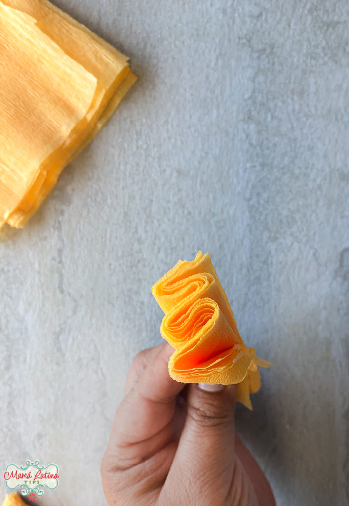 A person is holding a piece of crepe paper folded like an accordion.