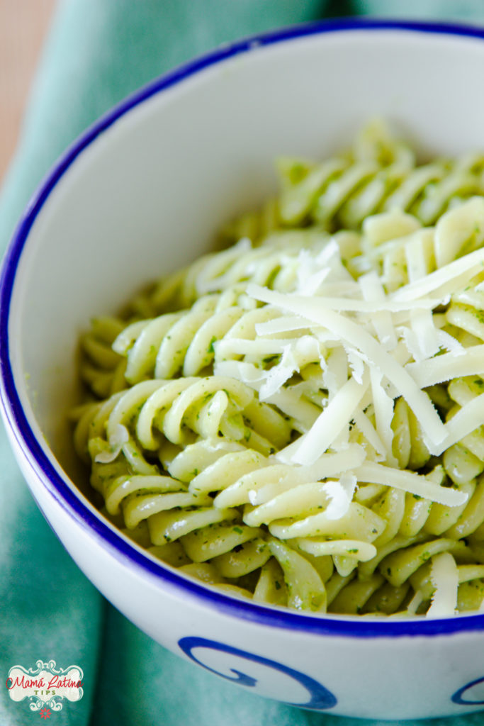 pasta con pesto y queso parmesano en tazón blanco 