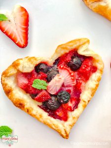 Heart shaped rustic tarts with berries, strawberries and mint
