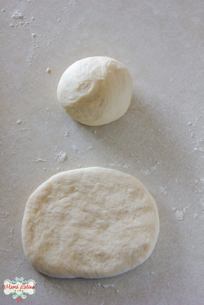 A flat oval of bread dough and a ball of bread