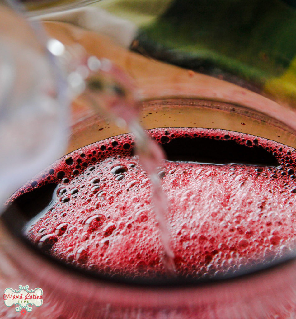 pouring agua de jamaica or hibiscus tea in a pitcher