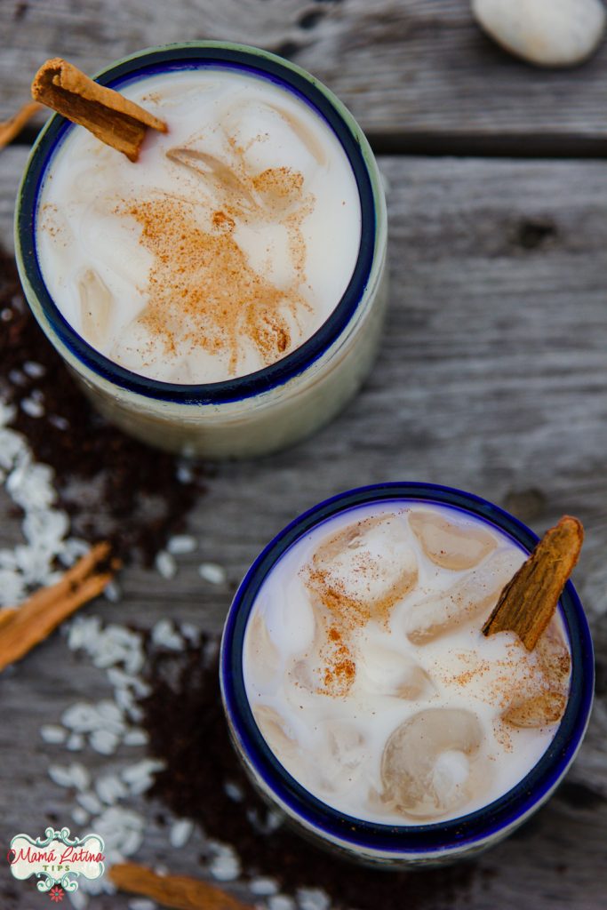 two Mexican glasses with horchata agua fresca and cinnamon