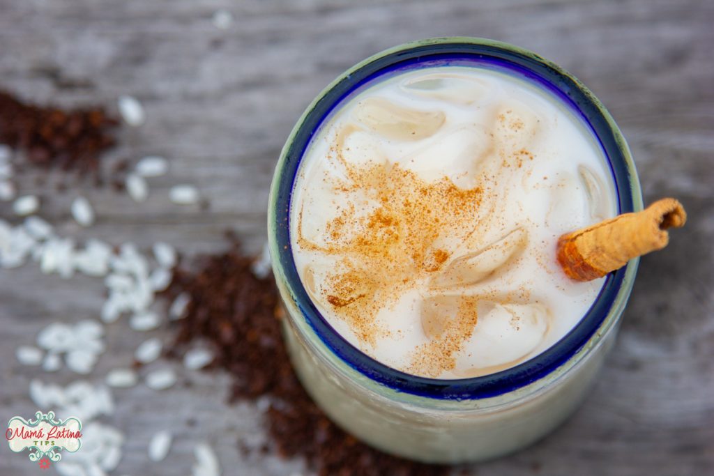 Un vaso de cristal con agua de horchata de café sobre una mesa de madera