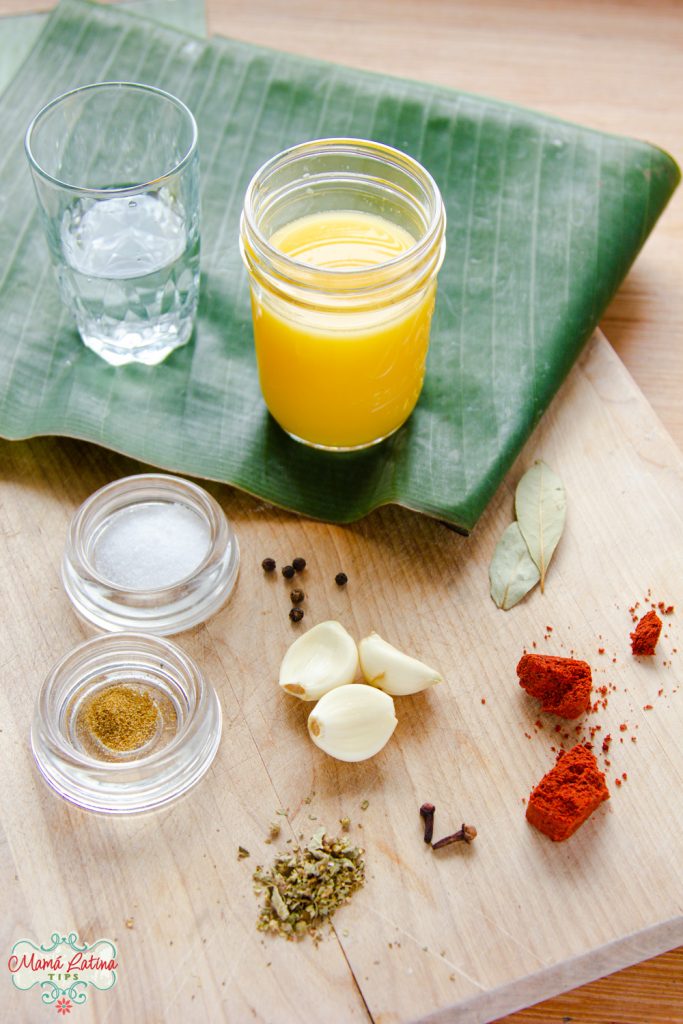 jugo de naranja, pasta de achiote, ajos, hojas de laurel especias y hojas de plátano