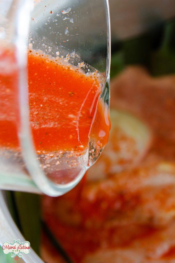 pouring pibil marinade on top of chicken