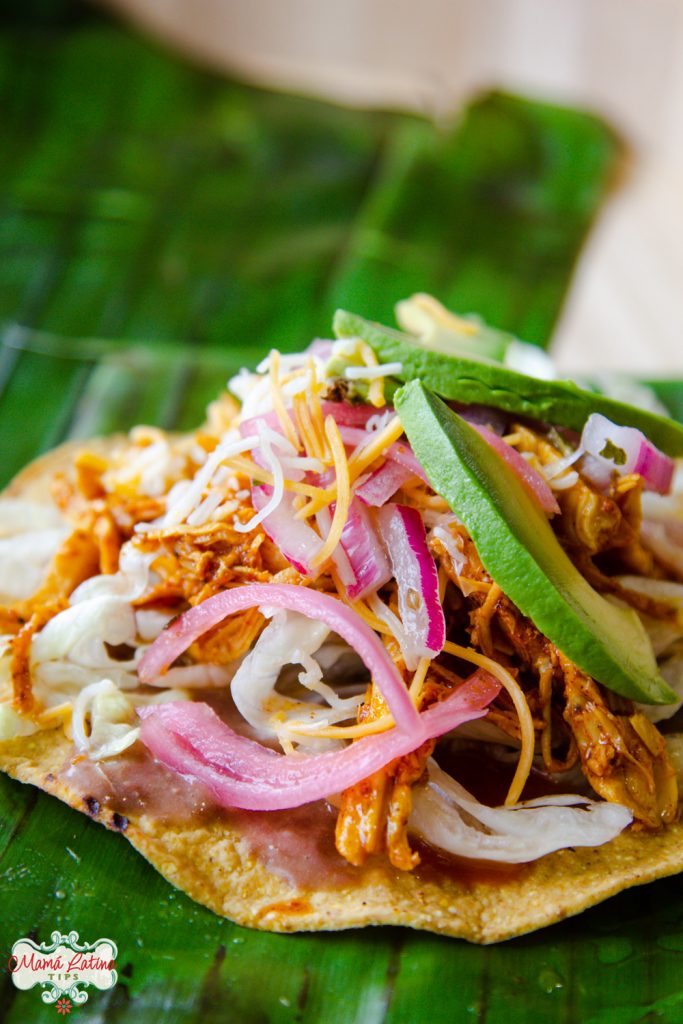 Tostada de pollo pibil con aguacate y queso.