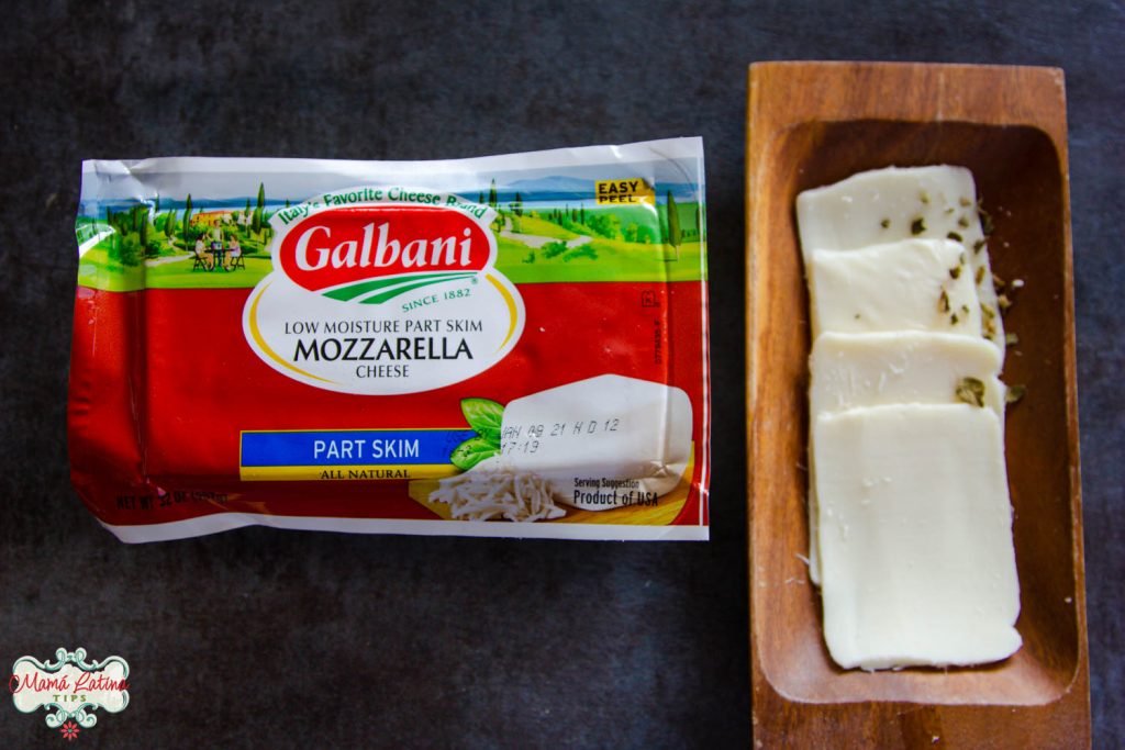 Un barra de queso mozzarella Galbani junto a un plato de madera con rebanadas del mismo queso