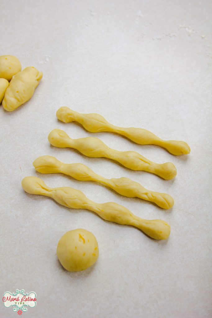 Four pieces of dough in the shape of "bones" next to a small ball of dough.