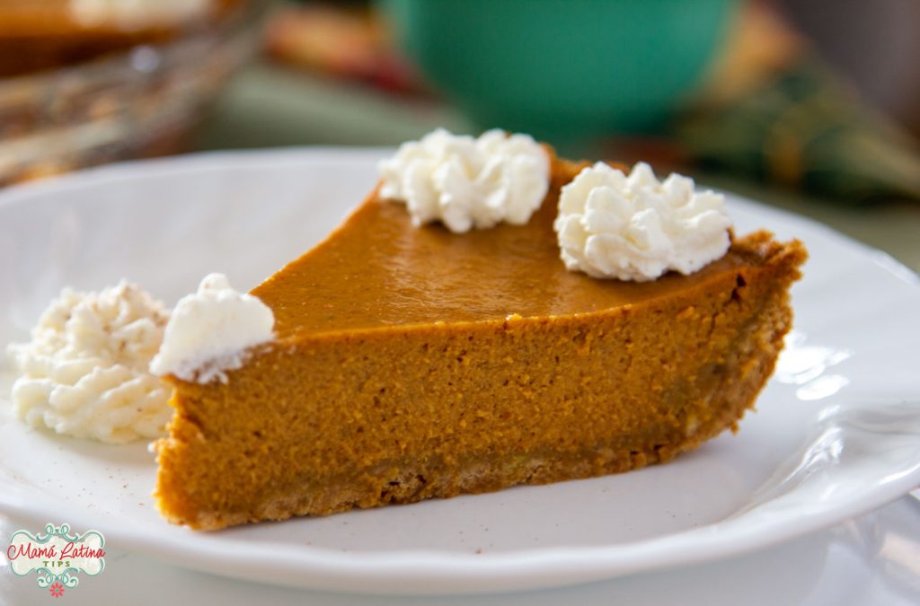 A slice of pumkin pie on a white plate