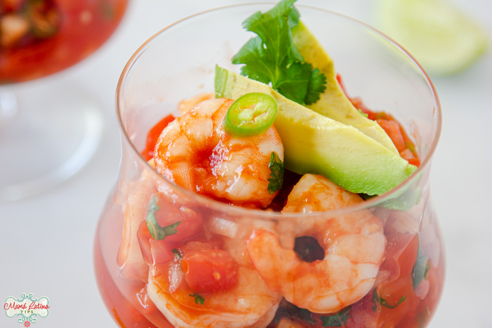 Mexican shrimp cocktail in a glass topped with avocado and a slice of pepper. Coctel de Camarón