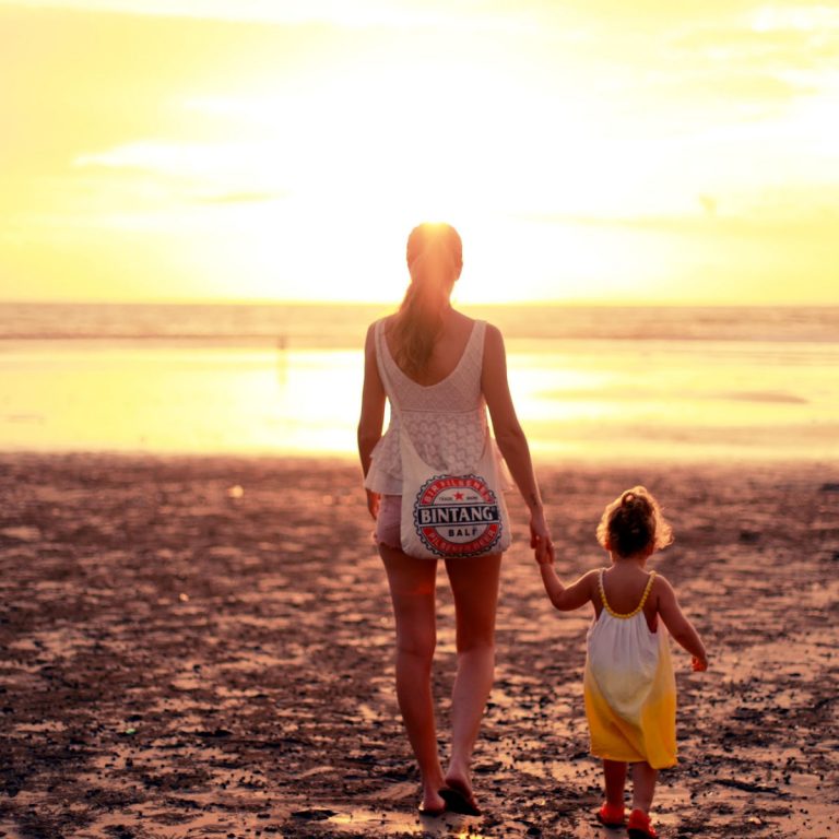 mom and daughter on the beach at sunset