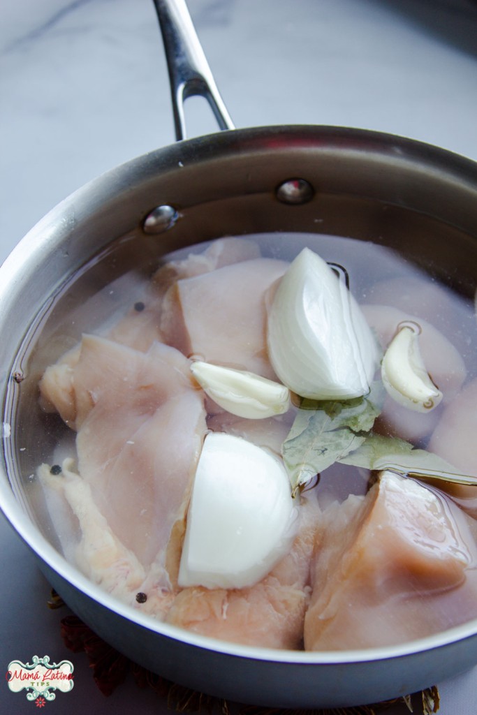 raw chicken with onions, garlic and bay leaves in a pot