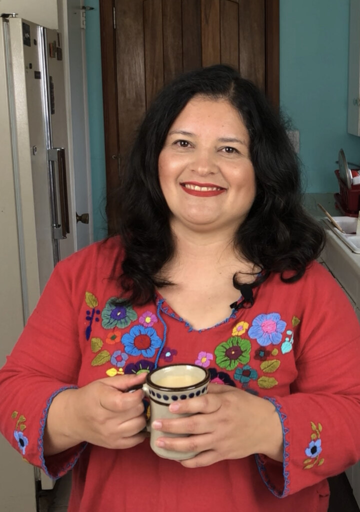 silvia martinez de person behind mamalatinatips.com wearing a Mexican red blouse with flowers and holding a cup with chocolate.