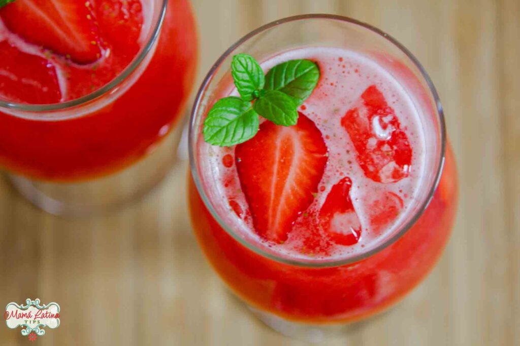 A top view of two glasses with Mexican strawberry agua fresca garnished with fresh mint