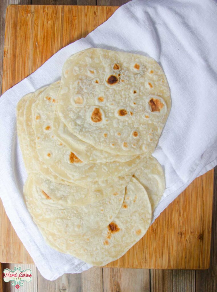 An easy homemade stack of flour tortillas on a cutting board.