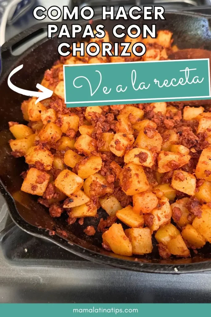 Una sartén de hierro fundido llena de papas cortadas en dados y chorizo se está cocinando. El texto sobreimpreso en español comparte una receta de Papas con Chorizo, una comida mexicana clásica.